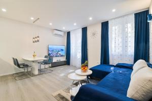 een woonkamer met een blauwe bank en een tafel bij Bacvice 21 in Split