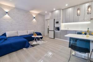 a living room with a blue couch and a kitchen at Bacvice 21 in Split +15 photos