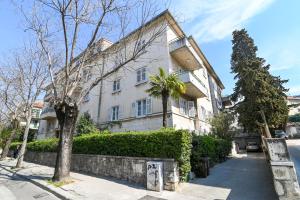 a white house with a tree in front of it at Bacvice 21 in Split