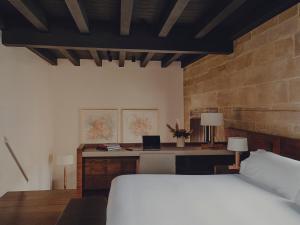 een slaapkamer met een bed en een bureau met een laptop bij Santa María Briones in Briones