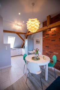 a dining room with a white table and green chairs at Apartamenty Centrum - Moonlight in Opole