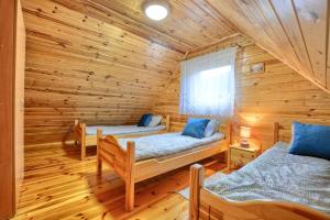 a room with two beds in a log cabin at Słoneczny Brzeg Polańczyk Domki 8-osobowe in Polańczyk