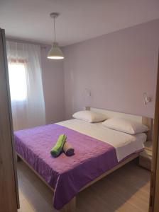 a bedroom with a bed with a pair of shoes on it at Apartment Paić in Kaštela