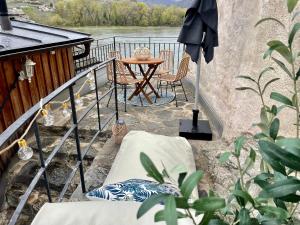 balcone con tavolo, sedie e ombrellone di Smile Apartments mit Donaublick a Dürnstein