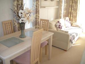 a living room with a table and a couch at Bri-ann's Seaside Holiday Home NO VANS OR LARGE VEHICLES in Selsey