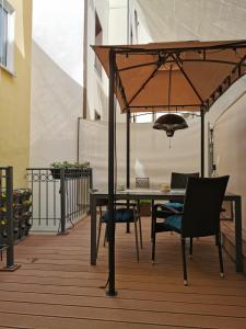 einen Tisch und Stühle unter einem Sonnenschirm auf dem Balkon in der Unterkunft Rheinufer am Hindenburgpark in Bingen am Rhein