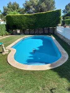 a large blue swimming pool in a yard at Can Che in Cala Galdana