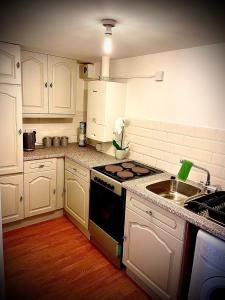 a kitchen with white cabinets and a stove top oven at T-post guest house in South Milford