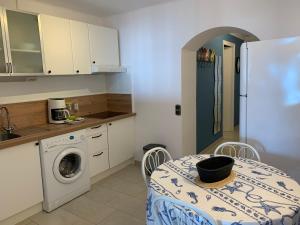 a kitchen with a table and a washing machine at AwayDays - BI - 41 in Empuriabrava