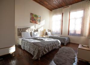 1 dormitorio con 2 camas y 2 ventanas en Lily Town Hotel, en Antalya