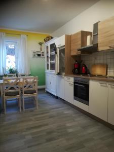 a kitchen with white cabinets and a table with a dining room at Ferienwohnung zur alten Post in Bad Grund