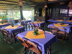 a room with blue tables and chairs with flowers on them at Pousada Rio Bracuhy in Angra dos Reis