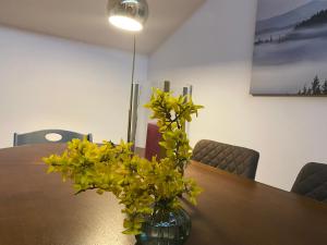 un jarrón lleno de flores amarillas sentadas en una mesa en Ferienwohnung Panoramablick - Alpenmagie Suites en Oberaudorf
