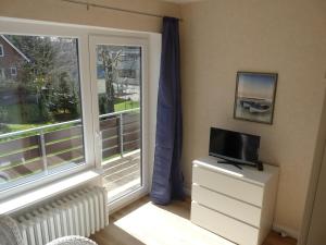 a living room with a tv and a window at Pension Haus Baltic in Dahme +51 photos