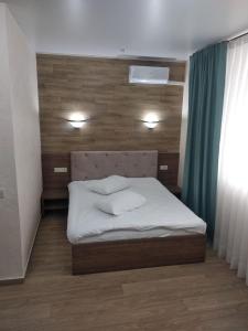 sypialnia z łóżkiem z zagłówkiem i oknem w obiekcie Fortetsya w Chmielnickim