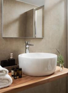 un lavandino bianco su un bancone in legno in bagno di Villa Itis - Elegant Ground Floor Suite with Terrace & Great View a Neapolis