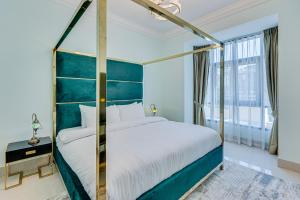 sypialnia z dużym łóżkiem z niebieskim zagłówkiem w obiekcie Souk al Bahar apartment near Burj Khalifa w Dubaju