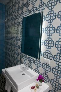 a bathroom with a white sink and a mirror at La Betulia Bed and Breakfast in Oaxaca City