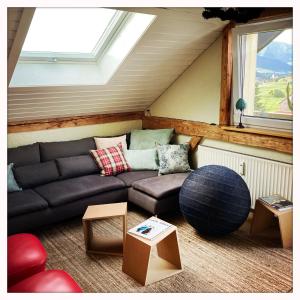a living room with a couch and a window at Oberstaufenblick.Allgäu in Stiefenhofen