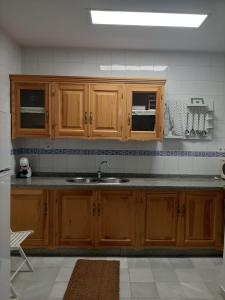 eine Küche mit Holzschränken und einem Waschbecken in der Unterkunft Apartamento Barrio Santa Cruz, centro Sevilla in Sevilla