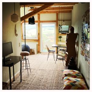 a person standing in a room with a table and chairs at Oberstaufenblick.Allgäu in Stiefenhofen