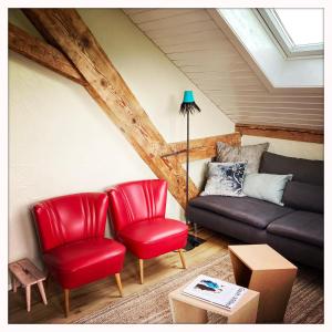 a living room with red chairs and a couch at Oberstaufenblick.Allgäu in Stiefenhofen