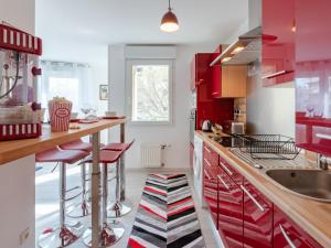 a kitchen with red cabinets and red bar stools at LE STELLA - HYPERCENTRE GARAGE GRATUIT WiFi NETFLIX AMAZON PRIME PROCHE PARC TETE D'OR in Villeurbanne
