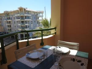 a table with a sink and a balcony with a building at hippocampe f2 in Fréjus