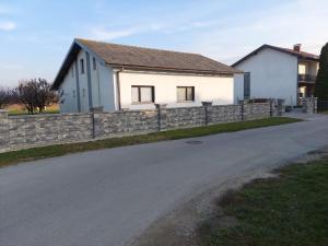 a house with a stone retaining wall next to a driveway at Suite Elena in Nedelišće