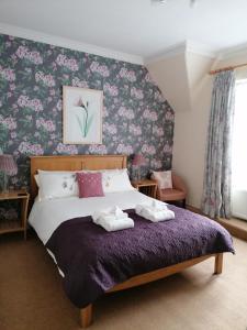 a bedroom with a large bed with a purple blanket at St Ann&rsquo;s Guest House in Inverness