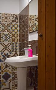 baño con dispensador de jabón rosa en un lavabo en Sokaku i te Marreve GuestHouse, en Gjirokastra