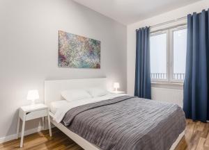 1 dormitorio con 1 cama y una pintura en la pared en City View Apartments, en Varsovia