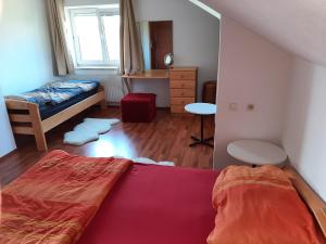 een kleine slaapkamer met een bed en een bureau bij Sundowner appartment at the lakeside - 120sqm in Schörfling