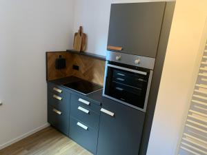 a kitchen with a black refrigerator and a stove at Lille Hygge in Clenze