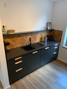 a kitchen with a black counter and a sink at Lille Hygge in Clenze