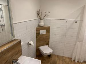 a white bathroom with a toilet and a sink at Lille Hygge in Clenze