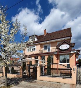 a large pink house with a clock on it at Éva Panzió in Sárvár