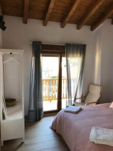 Schlafzimmer mit einem Bett und einer Tür zu einem Balkon in der Unterkunft El Rincon de Cabello in Sierra