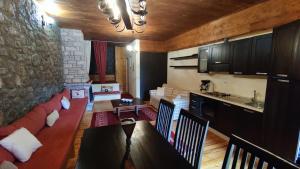 ein Wohnzimmer mit einem roten Sofa und einer Küche in der Unterkunft Traditional cozy apartments in Livadi Parnassos in Kalívia