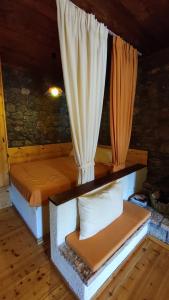Zimmer mit einem Bett mit Vorhang in der Unterkunft Traditional cozy apartments in Livadi Parnassos in Kalívia