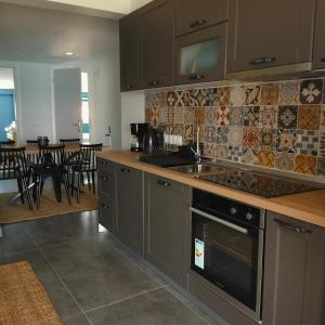 a kitchen with gray cabinets and a stove top oven at Sea Breeze luxury apartments in Nea Vrasna