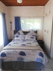 Schlafzimmer mit einem großen Bett und blauen Vorhängen in der Unterkunft Edward Cabana in Margate