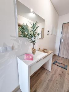baño con tocador blanco con espejo y flores en Elite Residente Gold 11, en Portimão