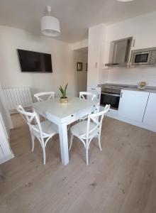 cocina blanca con mesa blanca y sillas en Apartamento Garmo Negro, en Jaca