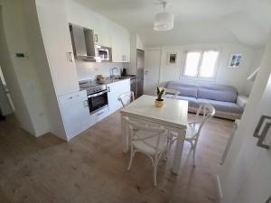 cocina y sala de estar con mesa blanca y sillas en Apartamento Garmo Negro, en Jaca