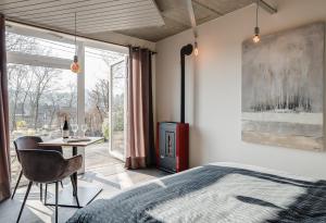 una camera da letto con un letto, una scrivania e una finestra di Le Garage a Theux