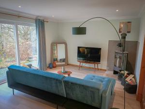a living room with a blue couch and a television at Aite-Sithiel in Kingsburgh