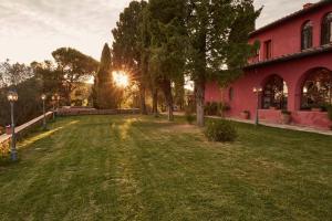 ein rotes Gebäude mit Sonnenuntergang im Hof in der Unterkunft Podere Somboli in Monte San Savino