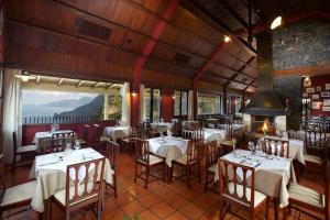 a restaurant with tables and chairs in a room at Hotel Quinta Do Furao in Santana