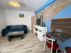ein Wohnzimmer mit einem blauen Sofa und einem Tisch in der Unterkunft Studio apartment Elsa in Galižana + 27 Fotos